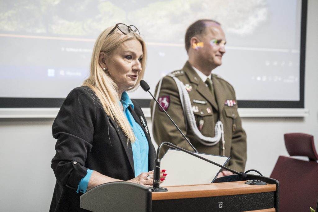 Pani Wiceprezydent Anna Augustyniak przemawiająca z mównicy, obok stoi Pan Komendant Szpitala Wojskowego